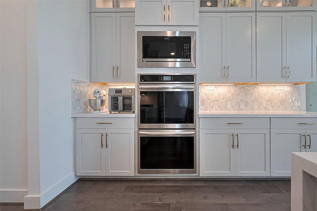 29851 Aaron River Trl, Fulshear, TX 77441 - kitchen featuring appliances with stainless steel finishes, decorative backsplash, light countertops, and glass insert cabinets