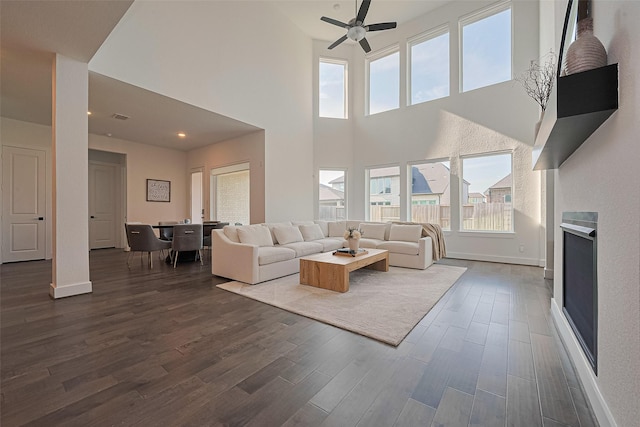 29851 Aaron River Trl, Fulshear, TX 77441 - living area with dark wood-style flooring, a ceiling fan, healthy amount of natural light, and a high ceiling