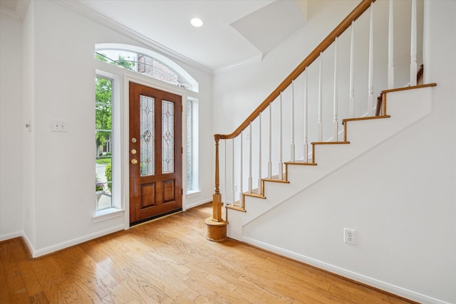 entrance foyer with wood finished floors, baseboards, ornamental molding, stairs, and recessed lighting