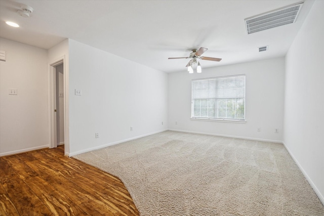 carpeted empty room featuring ceiling fan and baseboards