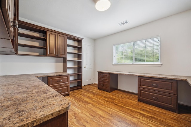 office space featuring built in desk and wood finished floors