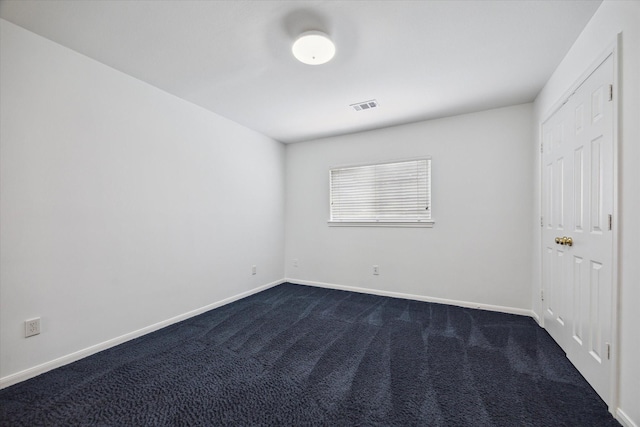 unfurnished bedroom with baseboards and dark carpet
