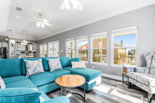 2296 Martinique, Crystal Beach, TX 77650 - living area featuring a ceiling fan, wood finished floors, ornamental molding, baseboards, and vaulted ceiling