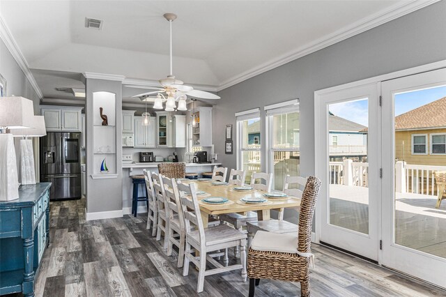 2296 Martinique, Crystal Beach, TX 77650 - dining area featuring dark wood-style flooring, a ceiling fan, crown molding, vaulted ceiling, and a raised ceiling