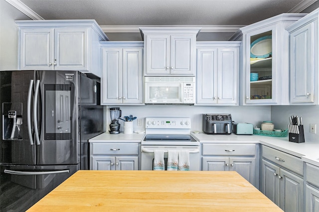 2296 Martinique, Crystal Beach, TX 77650 - kitchen with white appliances, ornamental molding, glass insert cabinets, and wooden counters