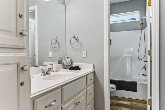 2296 Martinique, Crystal Beach, TX 77650 - bathroom with toilet, vanity, wood finished floors, and tub / shower combination