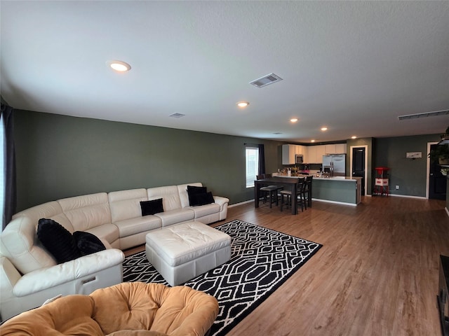 9810 Archdale Spring Dr, Baytown, TX 77521 - living room with dark wood-style floors, recessed lighting, and baseboards
