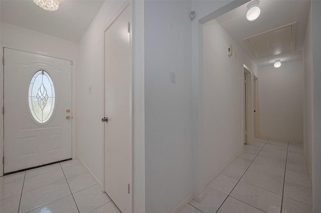 foyer entrance featuring light tile patterned floors and baseboards