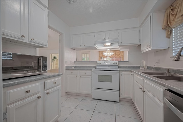 kitchen featuring appliances with stainless steel finishes, a sink, under cabinet range hood, white cabinetry, and a textured ceiling