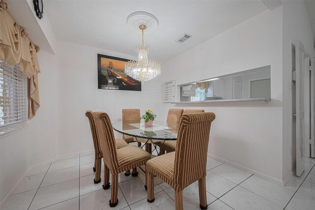 dining room featuring a chandelier, baseboards, and light tile patterned flooring