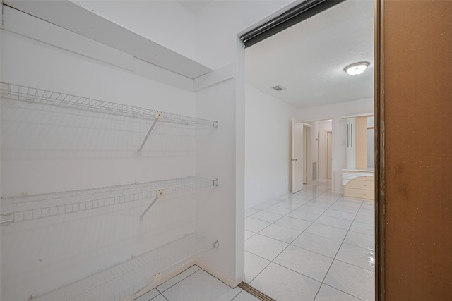 walk in closet featuring light tile patterned flooring