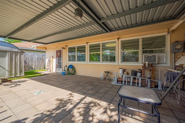 view of patio / terrace featuring fence, cooling unit, and an outbuilding