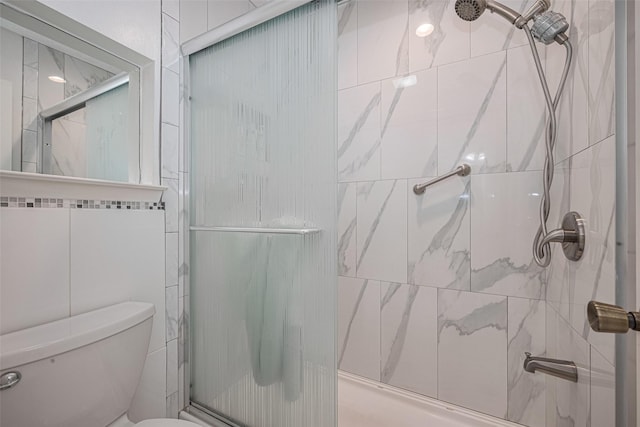 bathroom with a shower with shower door and toilet