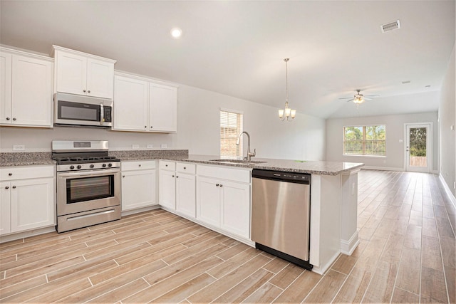 4401 E Bayou Maison Cir, Dickinson, TX 77539 - kitchen featuring appliances with stainless steel finishes, a sink, light wood-type flooring, a peninsula, and recessed lighting