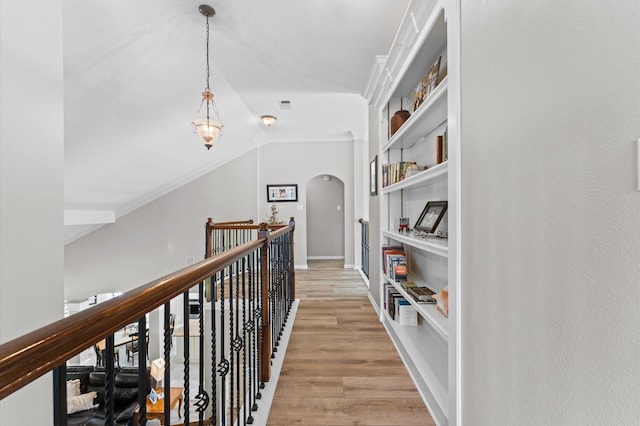 13502 Mount Airy Dr, Cypress, TX 77429 - corridor featuring arched walkways, light wood finished floors, built in shelves, vaulted ceiling, and crown molding