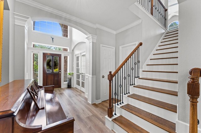 13502 Mount Airy Dr, Cypress, TX 77429 - foyer entrance with arched walkways, crown molding, wood finished floors, stairway, and a towering ceiling