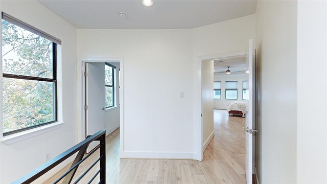 corridor with light wood-style floors and baseboards