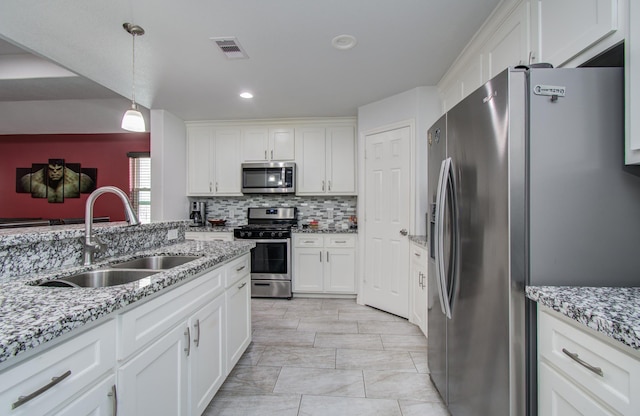 114 Dr Martin Luther King Jr Dr, La Porte, TX 77571 - kitchen with stainless steel appliances, a sink, white cabinets, tasteful backsplash, and recessed lighting