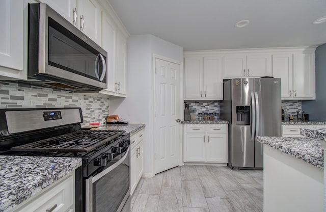 114 Dr Martin Luther King Jr Dr, La Porte, TX 77571 - kitchen featuring appliances with stainless steel finishes, white cabinetry, decorative backsplash, light stone countertops, and recessed lighting
