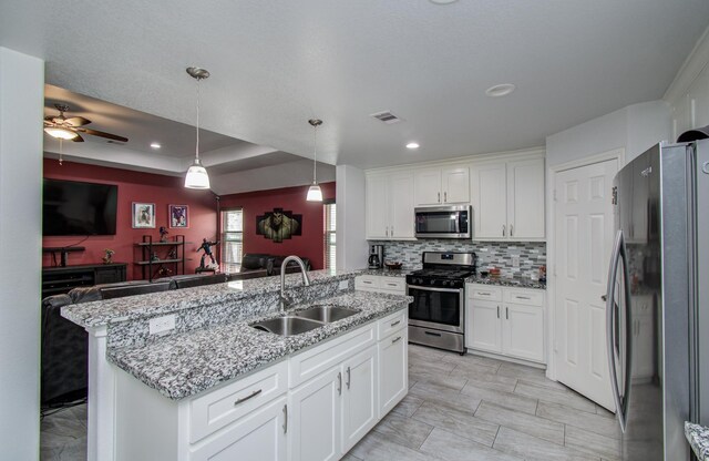 114 Dr Martin Luther King Jr Dr, La Porte, TX 77571 - kitchen featuring stainless steel appliances, a sink, open floor plan, white cabinets, and recessed lighting