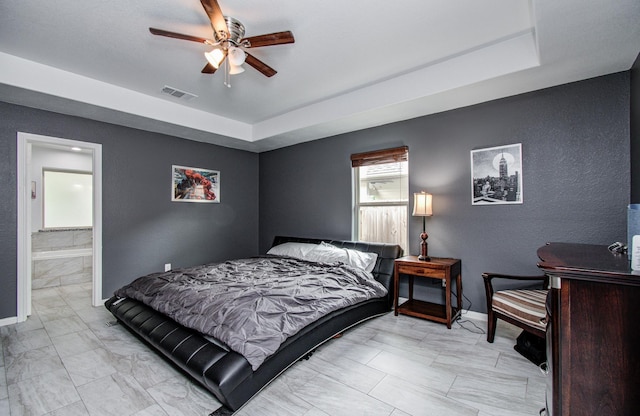 114 Dr Martin Luther King Jr Dr, La Porte, TX 77571 - bedroom with a tray ceiling, a ceiling fan, light marble finish flooring, a textured wall, and connected bathroom