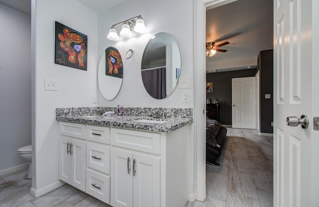 114 Dr Martin Luther King Jr Dr, La Porte, TX 77571 - bathroom with a ceiling fan, double vanity, baseboards, toilet, and connected bathroom