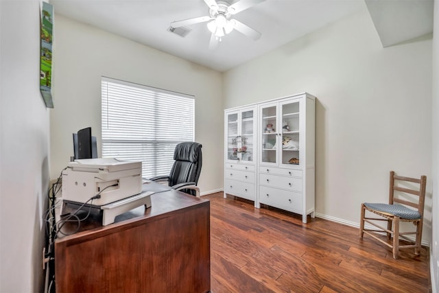 home office with dark wood-style flooring, a ceiling fan, and baseboards