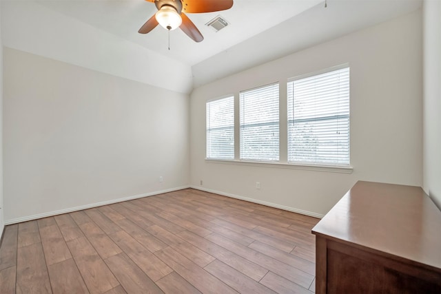 unfurnished room with a ceiling fan, light wood-type flooring, baseboards, and lofted ceiling