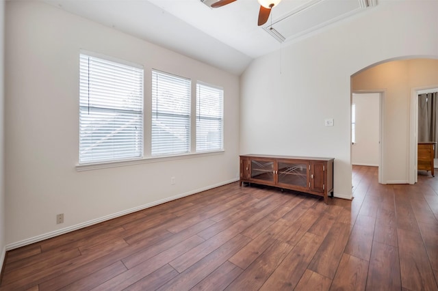 unfurnished room with arched walkways, ceiling fan, wood finished floors, baseboards, and lofted ceiling