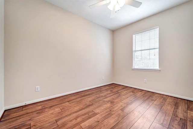 unfurnished room with a ceiling fan, wood finished floors, and baseboards
