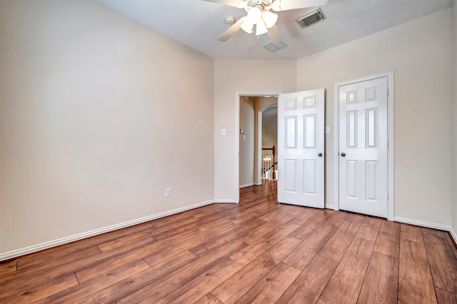 unfurnished bedroom featuring wood finished floors, baseboards, and ceiling fan