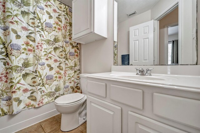 full bathroom with toilet, vanity, tile patterned floors, and baseboards
