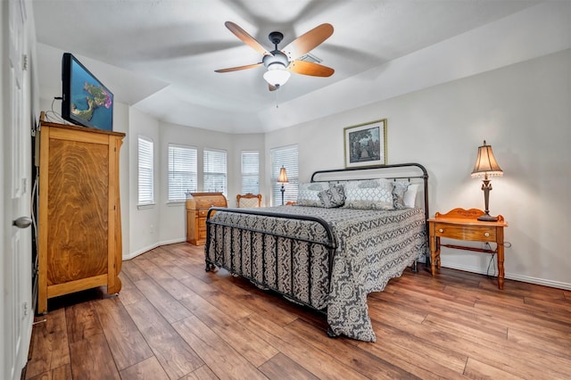 bedroom featuring baseboards, wood-type flooring, and ceiling fan