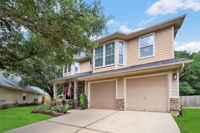 view of front of house featuring a garage, driveway, stone siding, and covered porch
