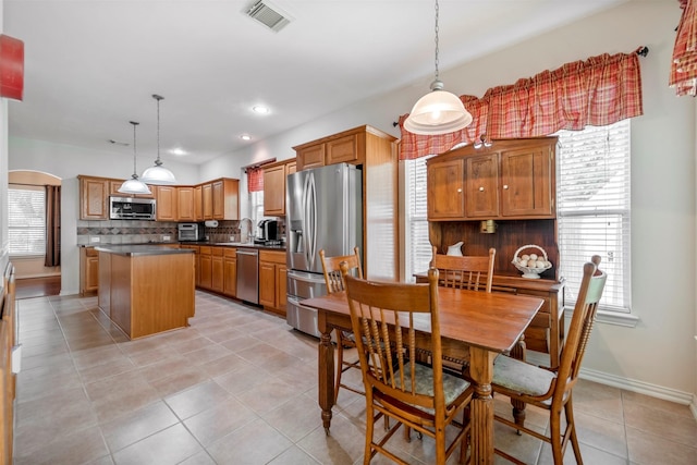 dining area with light tile patterned floors, baseboards, recessed lighting, and arched walkways