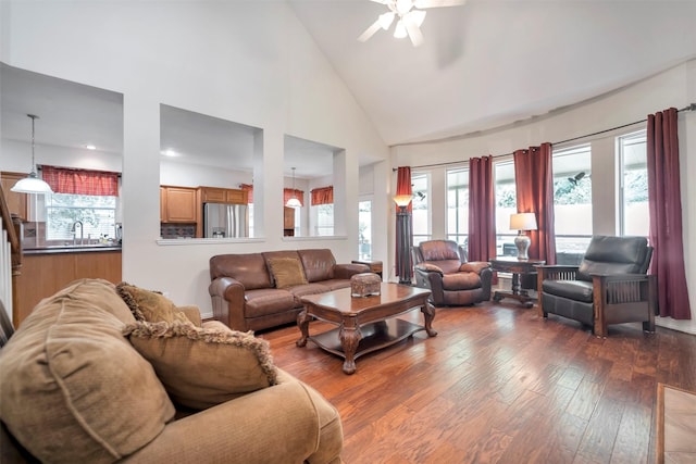 living room with wood-type flooring, a ceiling fan, and high vaulted ceiling