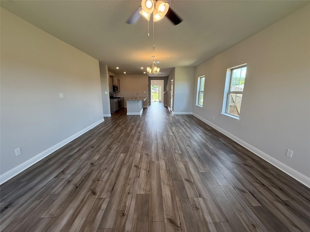 4329 W Bayou Maison Cir, Dickinson, TX 77539 - unfurnished living room featuring dark wood-type flooring, ceiling fan, baseboards, and a chandelier