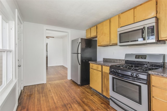 1614 Ursuline St, Galveston, TX 77550 - kitchen with stainless steel appliances, dark countertops, dark wood finished floors, and baseboards