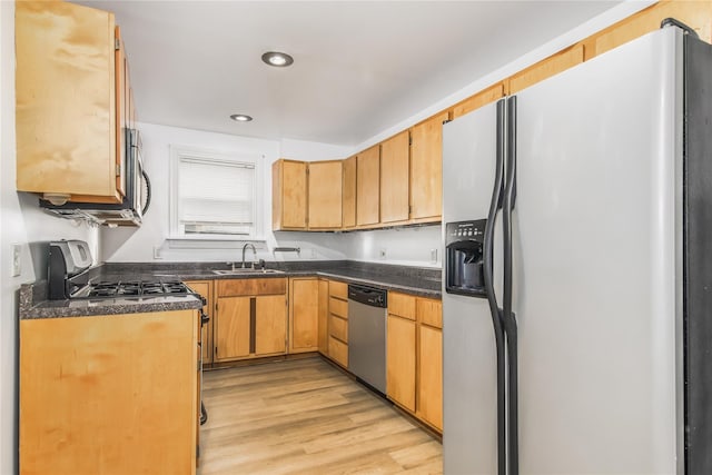 1614 Ursuline St, Galveston, TX 77550 - kitchen featuring appliances with stainless steel finishes, a sink, dark countertops, light wood-style flooring, and recessed lighting