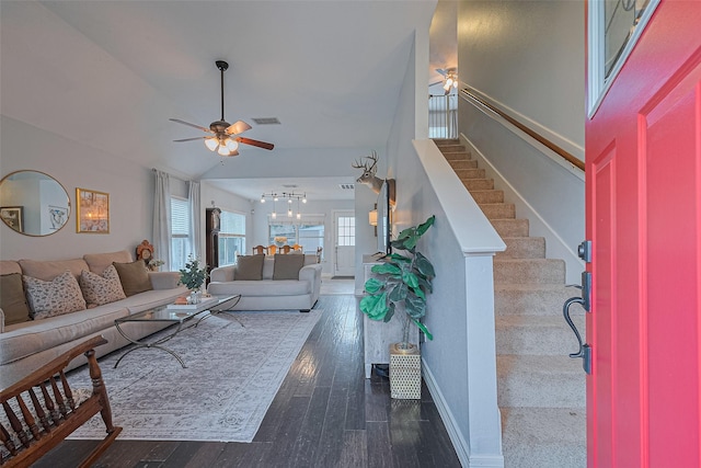living area featuring ceiling fan, stairs, dark wood-type flooring, a chandelier, and lofted ceiling
