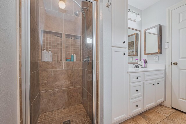 bathroom featuring a stall shower, vanity, and tile patterned flooring