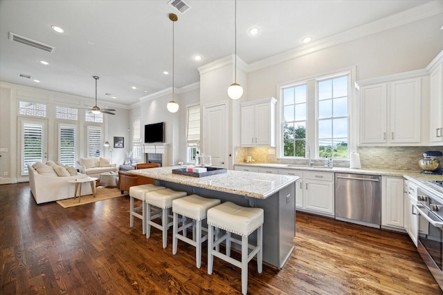 2729 Cohn St, Houston, TX 77007 - kitchen featuring stainless steel appliances, ceiling fan, crown molding, white cabinetry, and a sink
