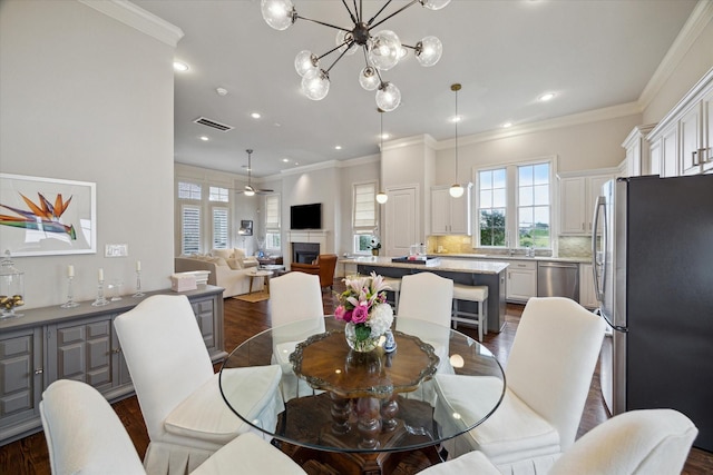 2729 Cohn St, Houston, TX 77007 - dining room with dark wood-type flooring, crown molding, recessed lighting, and a chandelier