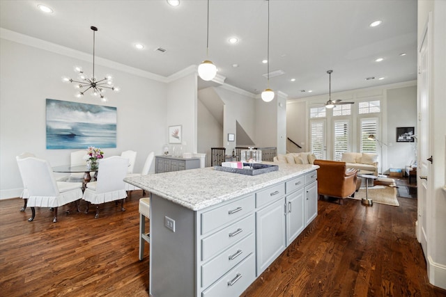 2729 Cohn St, Houston, TX 77007 - kitchen featuring crown molding, a center island, dark wood-style flooring, open floor plan, and a kitchen breakfast bar
