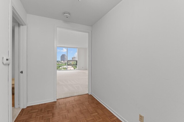 hallway featuring baseboards and carpet