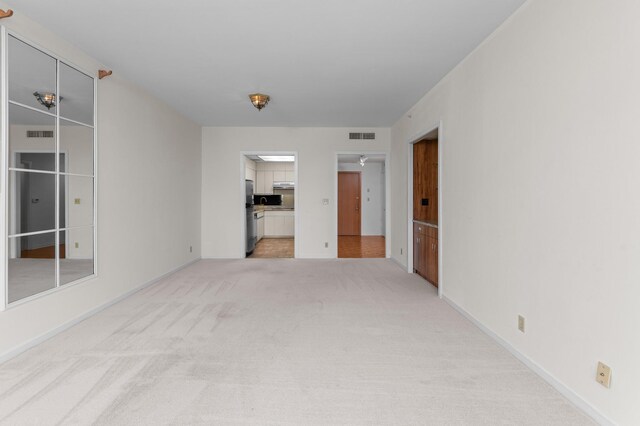 unfurnished room featuring light colored carpet