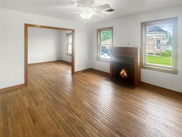 320 E S Main St, Flatonia, TX 78941 - unfurnished living room with wood-type flooring, a fireplace with flush hearth, and baseboards