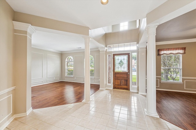 1301 Wilderness Pines Dr, Friendswood, TX 77546 - entrance foyer featuring light tile patterned floors, decorative columns, crown molding, baseboards, and a decorative wall