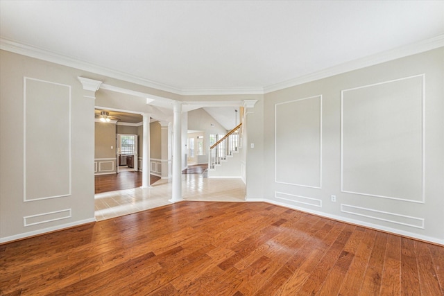 1301 Wilderness Pines Dr, Friendswood, TX 77546 - unfurnished room with ornate columns, a decorative wall, crown molding, wood finished floors, and stairway