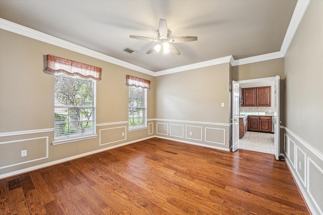 1301 Wilderness Pines Dr, Friendswood, TX 77546 - spare room with ornamental molding, ceiling fan, light wood finished floors, a wainscoted wall, and a decorative wall